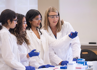 Instructor showing students a vial in a science lab